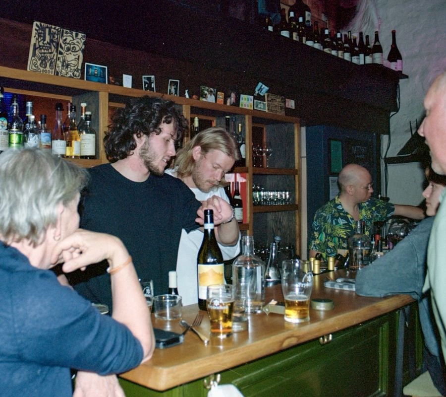 Gjester som blir servert drikke og mennesker som jobber i en bar.